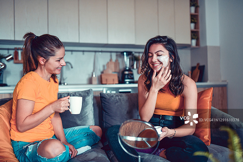 女性朋友在家里厨房喝咖啡、试用护肤霜图片素材