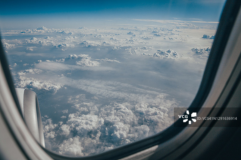 从飞机窗口看多云的天空。旅行的概念。蓝色的颜色。地平线上的观点。图片素材