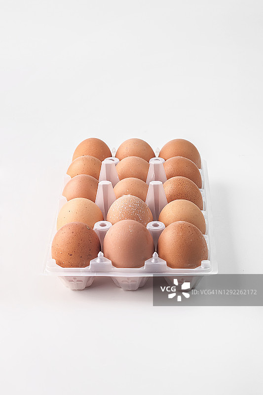 食物摄影的清洁塑料包装的棕色农场鸡蛋侧视图上的浅灰色背景孤立近距离图片素材