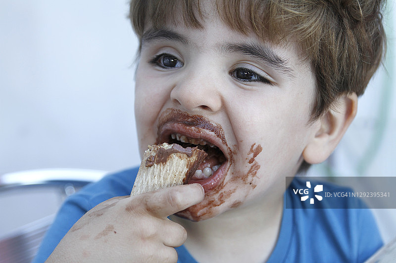 男孩正在吃巧克力冰淇淋图片素材