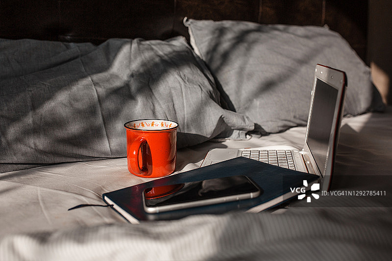 咖啡杯放在木桌上，早上在卧室里喝咖啡提神，生活和工作的地方图片素材