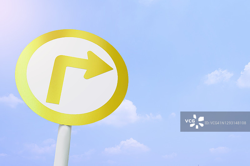 金色交通标志显示在蓝天上右转，图片素材