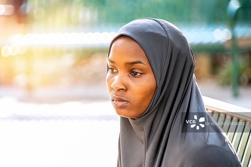 沉思严肃的年轻黑人穆斯林妇女戴着头巾看向别处图片素材