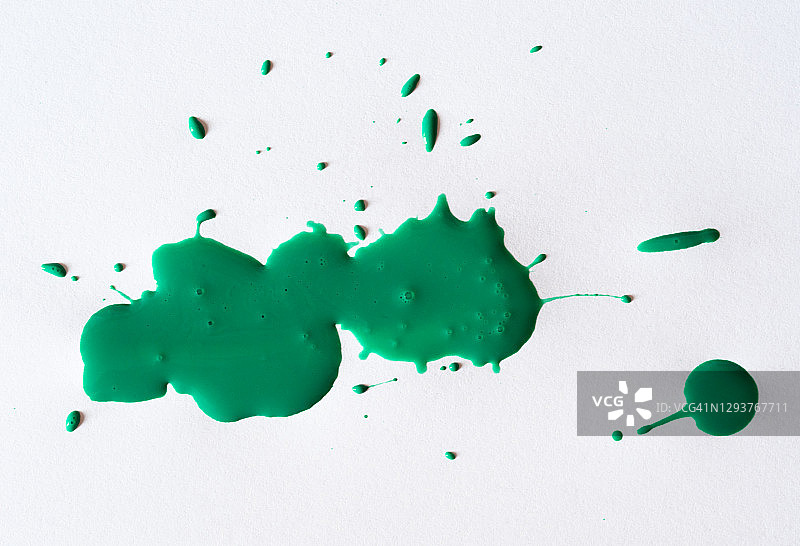 抽象的背景，绿色的颜料滴在白色的画布上。图片素材