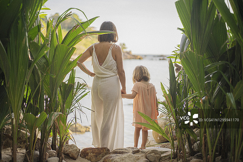 母亲和女儿牵着手在热带海滩，泰国图片素材