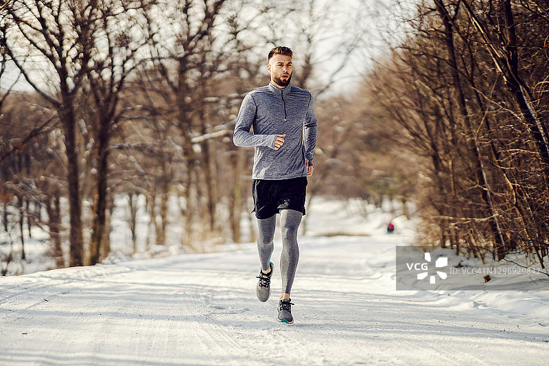适合冬季在雪地上奔跑的运动员。健康的生活方式，冬天健身，寒冷的天气图片素材