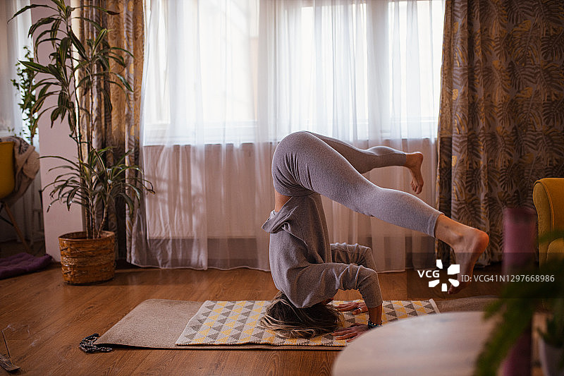 女子练习瑜伽头倒立图片素材