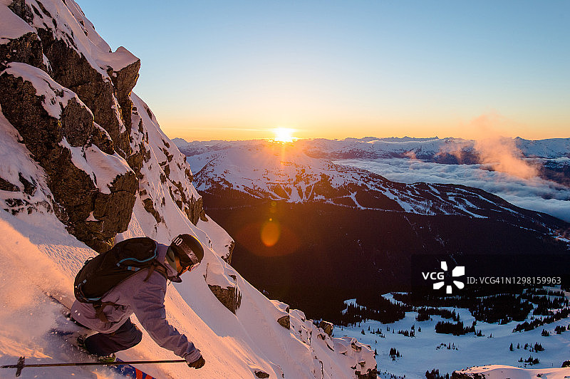 黎明时分，一个偏远地区的滑雪者从陡峭的粉斜坡上下来图片素材