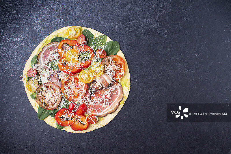 横幅披萨配奶酪，西红柿，培根，胡椒，菠菜。在蓝色背景上。水平方向。图片素材