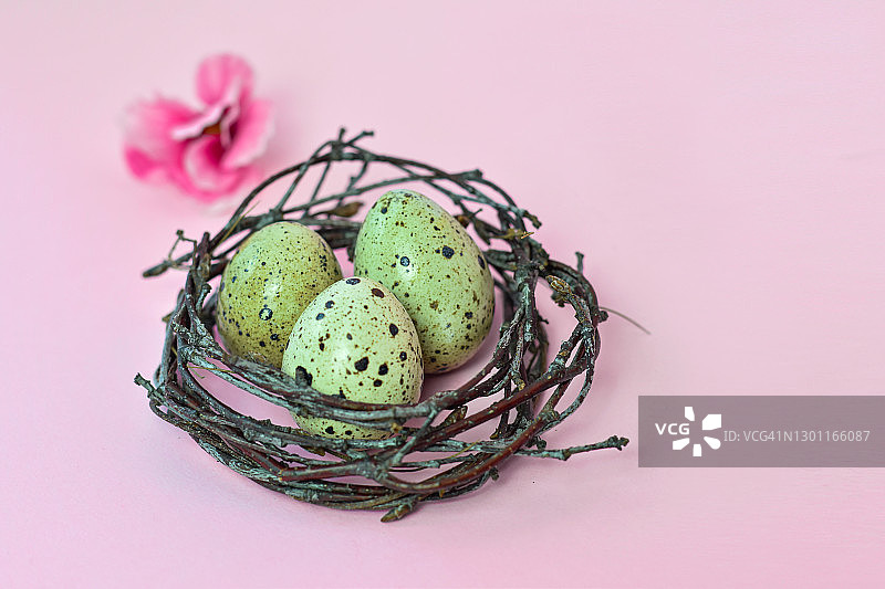 复活节快乐。DIY兔子，鸡蛋和粉红色的背景花。复活节卡片是用自制的图案装饰的。图片素材