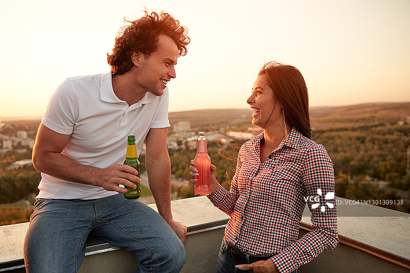 欢快的夫妇在屋顶上喝啤酒图片素材