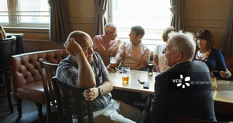 一群退休朋友在英国酒吧里闲逛的小对话图片素材