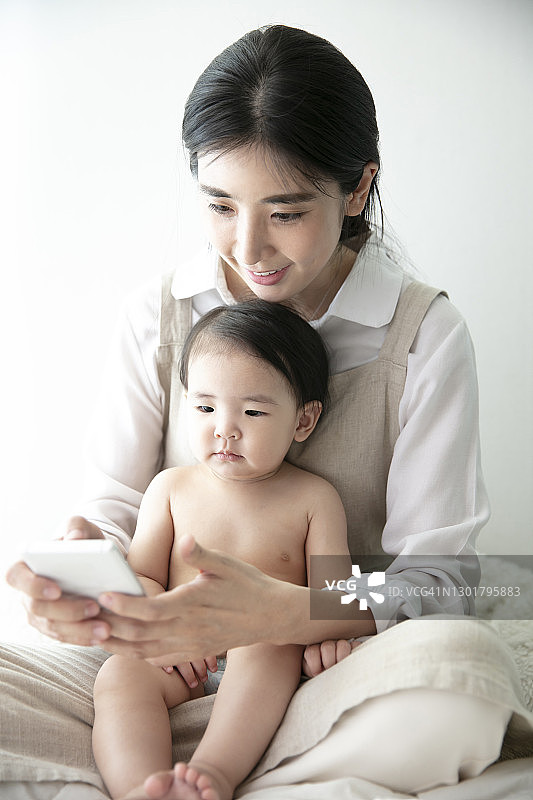 妈妈和宝宝看智能手机图片素材