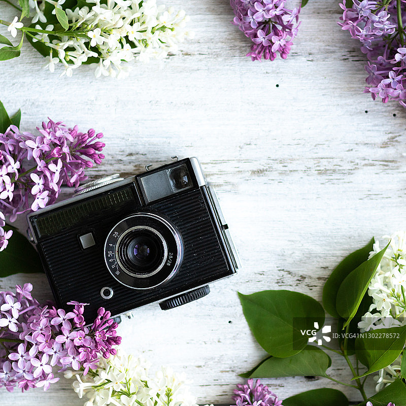 镜头放在木质的白色背景上，背景是淡紫色的花朵，对焦柔和图片素材