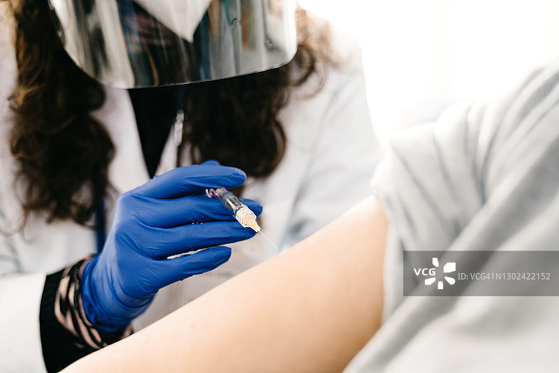 一位女医生给一位女士接种疫苗时的细节图片素材