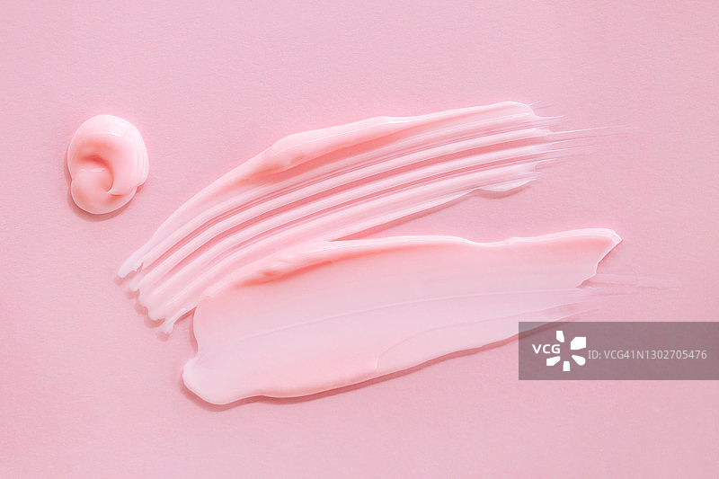 纹理涂抹玫瑰奶油在粉红色的背景。今年流行的产品。健康和健康概念。为您的设计复制空间图片素材
