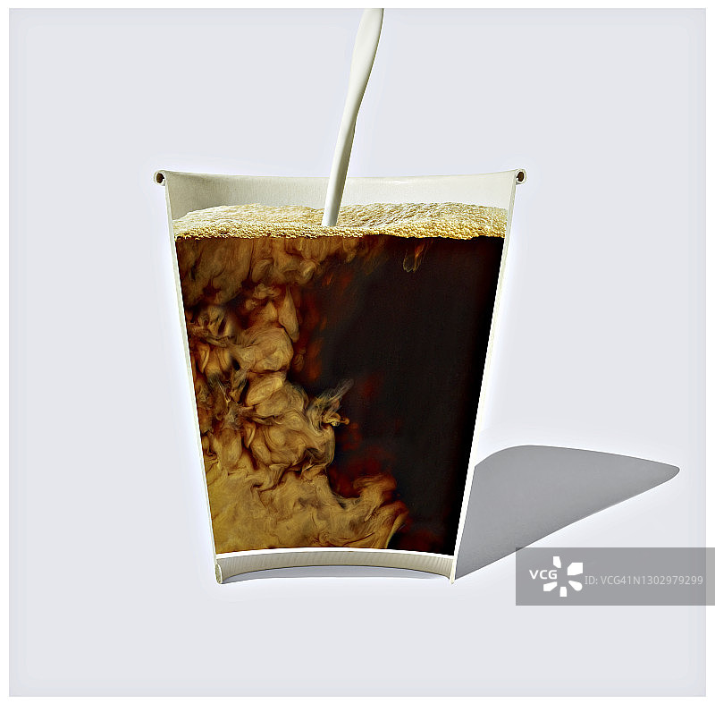 一次性杯中牛奶与咖啡的混合截面图片素材