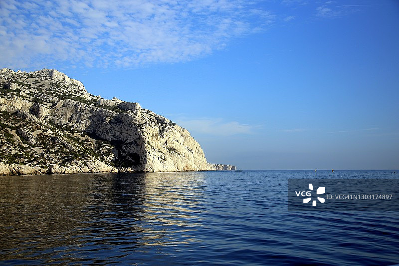 法国马赛，卡兰克斯国家公园，岩石悬崖和它在蓝色的地中海上的倒影图片素材