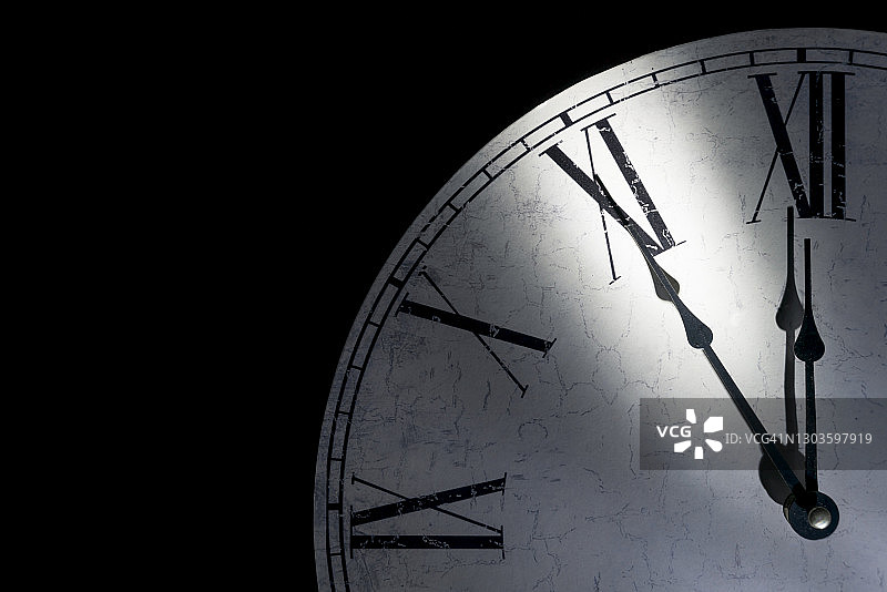一个古董挂钟的细节显示距离午夜还有五分钟，象征时间已到图片素材