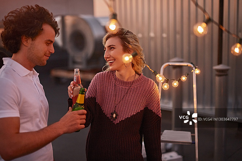 欢乐的夫妇在派对上喝啤酒聊天图片素材