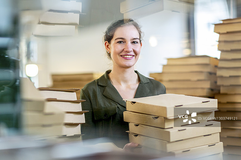 年轻女性小企业主，披萨盒图片素材