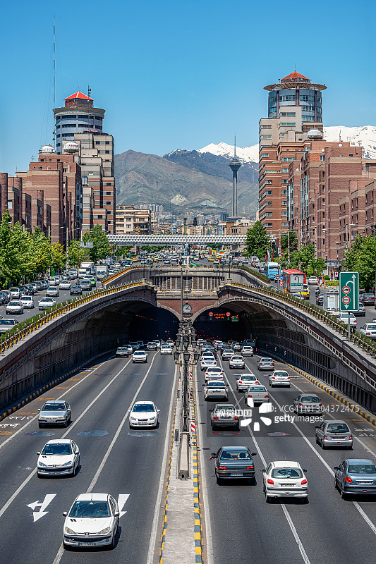 06/05/2019德黑兰，伊朗，著名的德黑兰，内部的交通流量，上方和附近的Tohid隧道，以米拉德塔和阿尔伯兹山为背景，Tohid隧道是中东最长的城市隧道之一图片素材