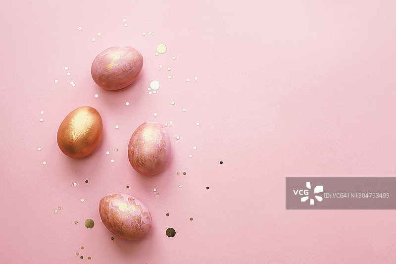 彩色的复活节彩蛋在粉红色的背景。节日贺卡。图片素材