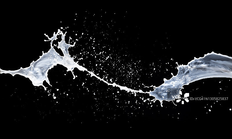 白色液体(牛奶)在黑色背景上产生飞溅和掉落的震动。图片素材
