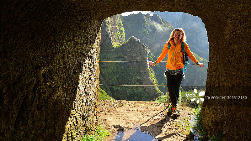 美丽的年轻女子在马德拉岛徒步旅行的山路上，从一个男人制造的隧道，大西洋，葡萄牙图片素材