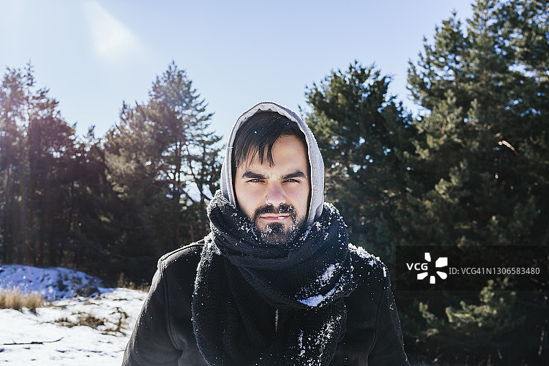 有胡子的人穿着暖和的衣服站在积雪覆盖的土地上，对着天空图片素材