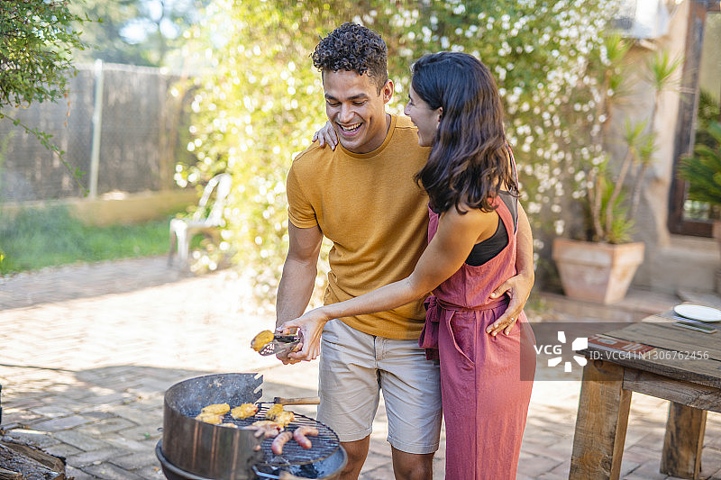 大笑的年轻夫妇一起在户外烧烤图片素材