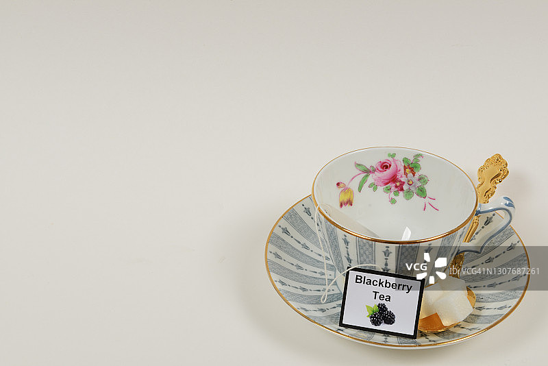 白色背景的茶杯和茶碟，茶包，勺子和方糖图片素材