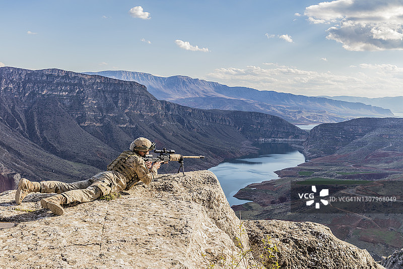 军队狙击手正在悬崖顶上瞄准他的目标图片素材