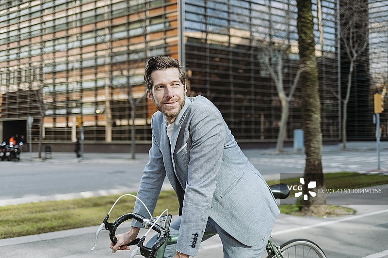 在城市里骑着自行车的男性通勤者看向别处图片素材