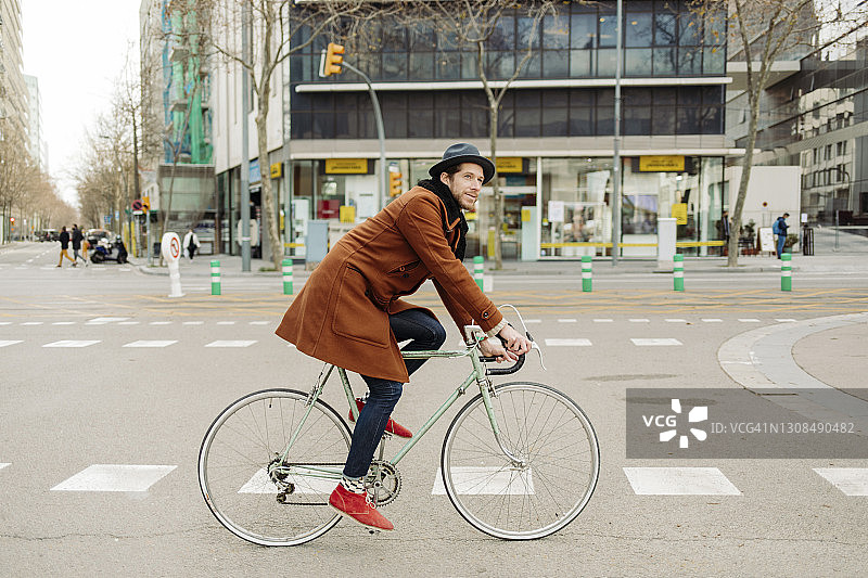 中年男性潮人在城市里骑自行车图片素材