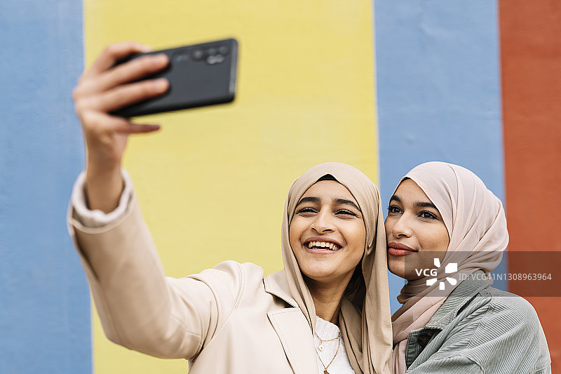 两个阿拉伯女性朋友正在用手机自拍。图片素材