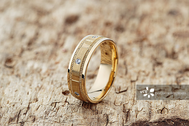 现代纹理婚戒装饰与钻石在木材背景图片素材