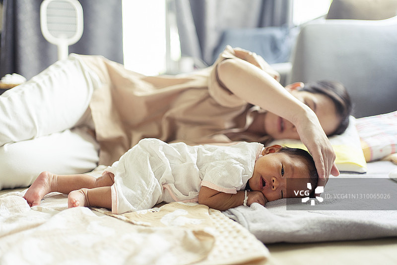 近距离观察可爱的亚洲新生儿和她的母亲在家里睡觉图片素材
