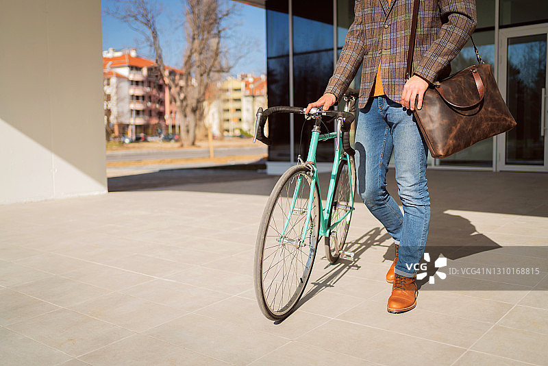 一个面目全非的时尚商人骑自行车上班图片素材