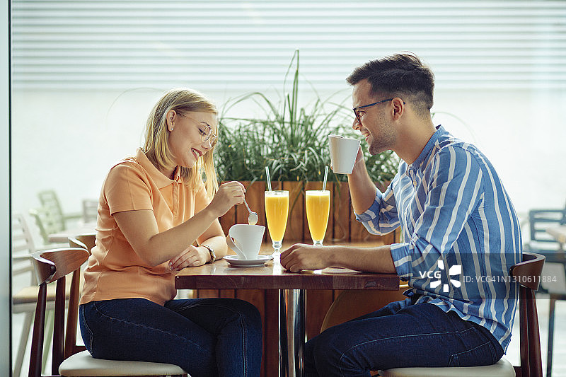 年轻的白种人夫妇在他们的约会在咖啡店里玩图片素材