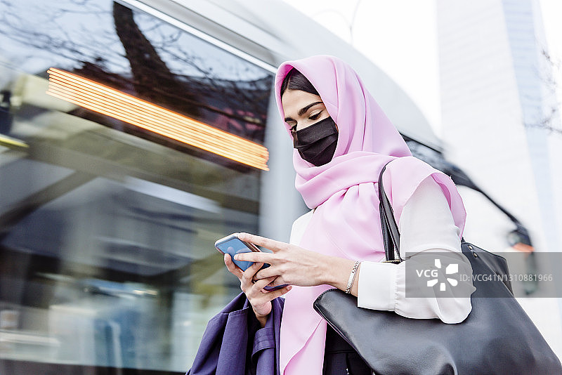 一个年轻的阿拉伯妇女在等公共汽车图片素材