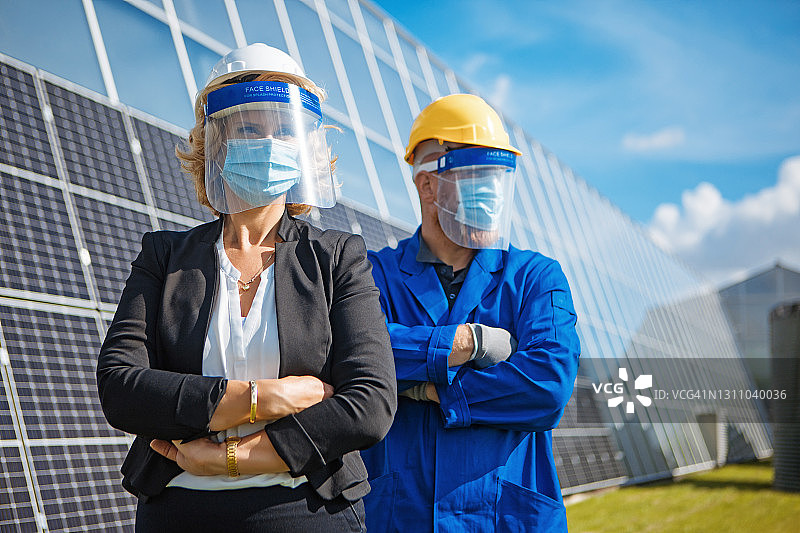 科罗娜的做法，一个女性经理和男性工人工程师在太阳能电池板基地图片素材