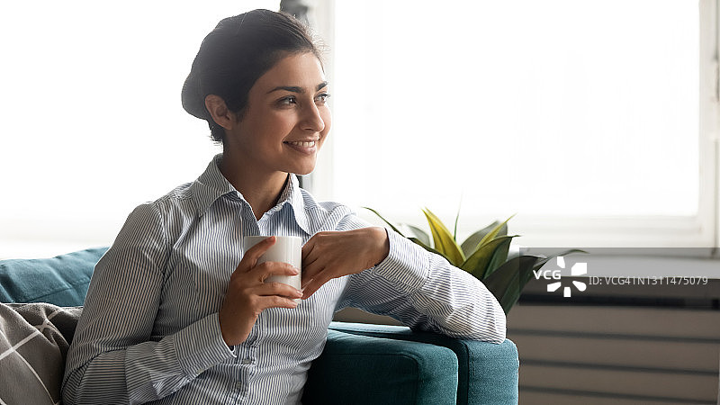 印度女子在室内休息时喝着茶做白日梦图片素材