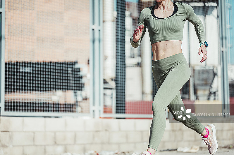 成熟的女人穿着运动服跑步图片素材