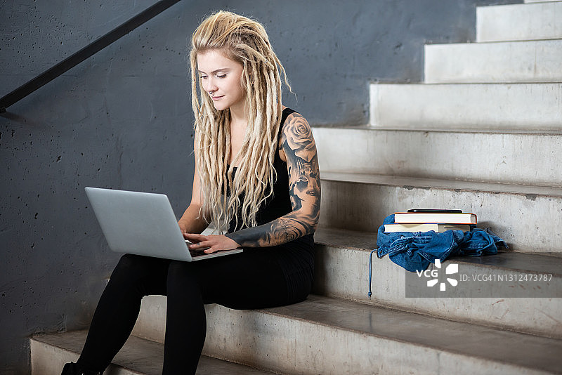 纹身的女人正在用笔记本电脑工作图片素材
