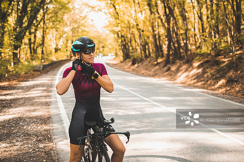 准备骑自行车和戴头盔的妇女。专业的铁人三项运动员图片素材