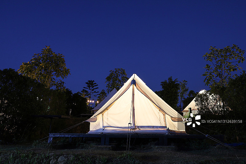 白色的帐篷晚上在花园里露营图片素材