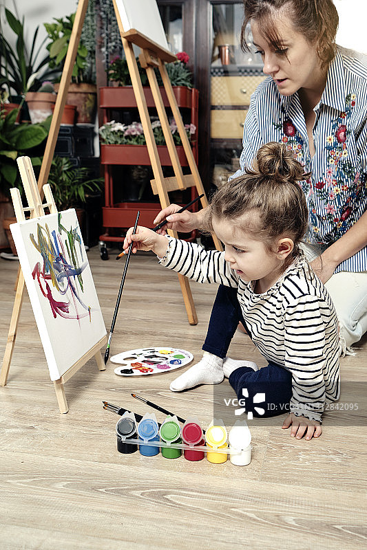 一个两岁的女孩正在和她的妈妈画画图片素材