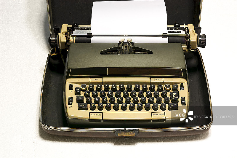 老式打字机和一张白纸。孤立在白色背景上。图片素材