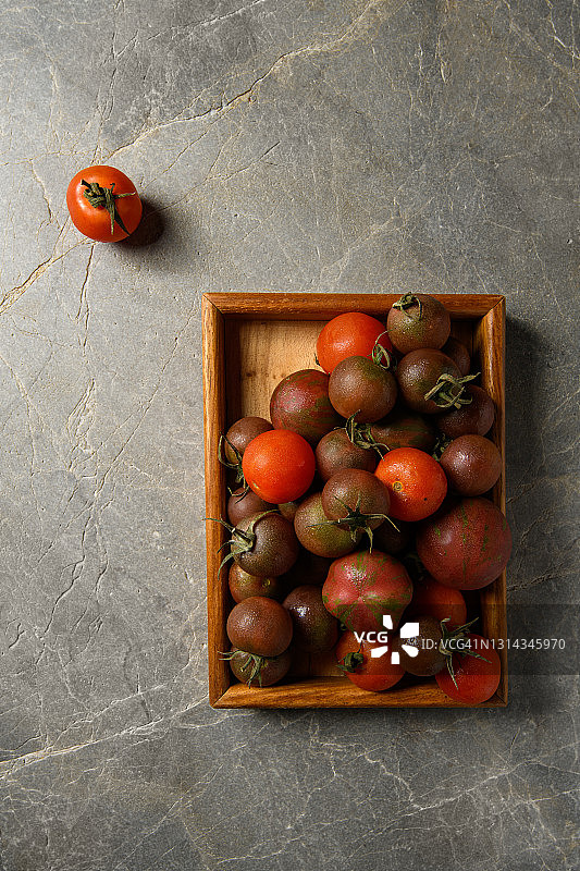 不同大小的西红柿在一个木材容器图片素材